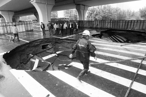 中原路西三環(huán)立交橋下由南向北原本4個車道，由于塌坑，而今3個車道被圍擋