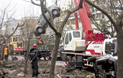 輸油管道爆炸后，搶修人員將被炸毀的車輛運出現(xiàn)場。