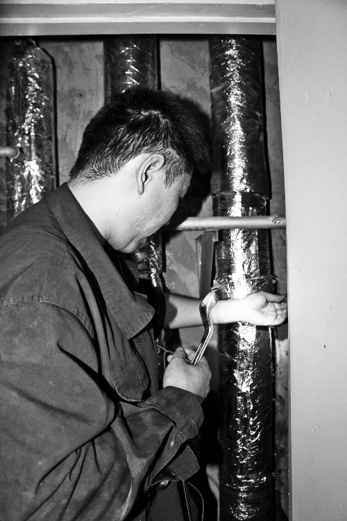 苗師傅一邊進行維修，一邊用耳機接聽市民的電話。