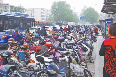 省人民醫(yī)院北門，路邊的公交站牌處停滿非機動車，上、下客只能在快車道上。