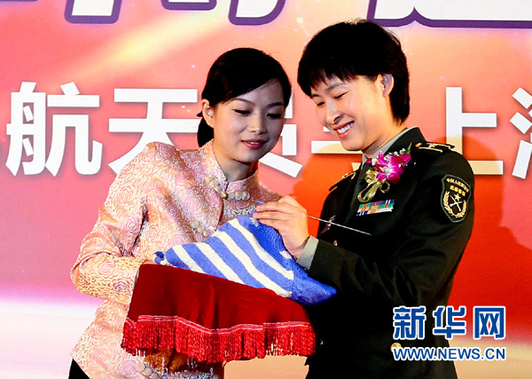 11月1日，航天員劉洋（右）在為“愛心”毛衣編織最后的收尾針。