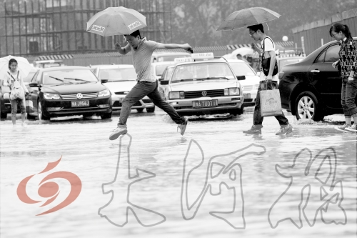 鄭州經(jīng)三路與北環(huán)交叉口處，積水較深，行人們不得不“練輕功”。 記者 白周峰 攝影