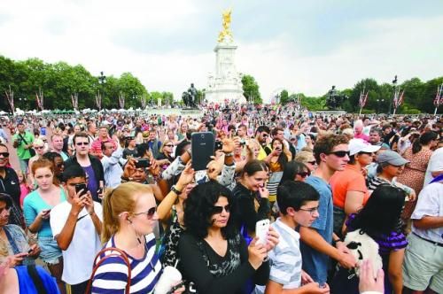 7月23日，在英國倫敦白金漢宮外，民眾們爭相閱讀“王室寶寶”出生的正式公告。