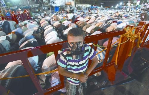 當(dāng)?shù)貢r(shí)間28日晚，在埃及開羅納賽爾城，一名小男孩頭戴防毒面具參加穆兄會(huì)的集會(huì)示威。