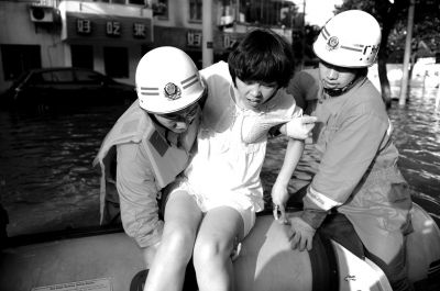 10月10日，前來余姚支援的杭州消防支隊武警官兵在南西路幫助轉(zhuǎn)移被困群眾。新華社發(fā)