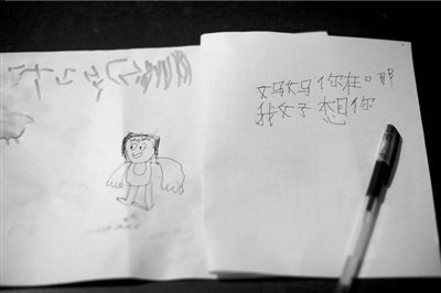 名叫袁明燕的小姑娘用筆在紙上不斷寫“媽媽”二字。