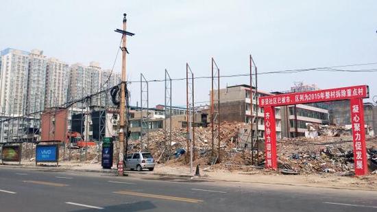 015年5月31日，在社區(qū)干部的帶頭拆遷下，親賢社區(qū)的“城中村改造”拉開(kāi)帷幕。由于前期“清產(chǎn)核資”及補(bǔ)償標(biāo)準(zhǔn)等因素，拆遷改造工作推進(jìn)并不順利。圖為位于體育西路東側(cè)集體所有的商鋪率先被拆遷完畢，用于遮擋的圍擋正在施工中。（拍攝：2015年9月16日）