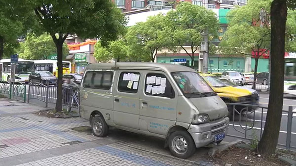 被棄置在人行道上的面包車。