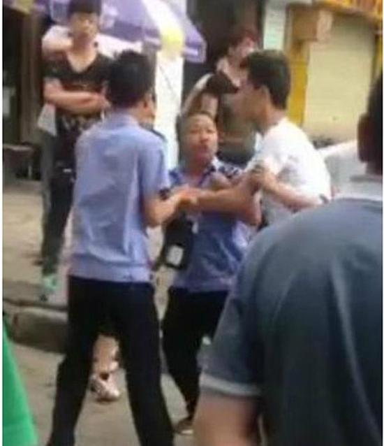 付某（右）與城管執(zhí)法人員廝打在一起。