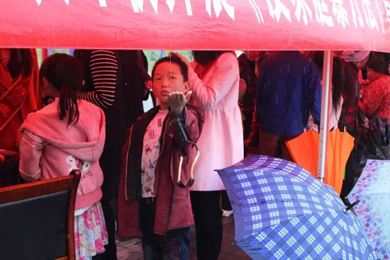 因為雨下的太大，小男孩玩起了接水游戲。