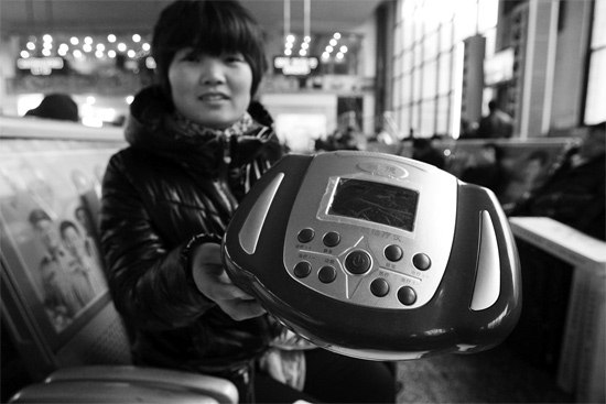 火車站候車室，李女士向記者展示她準(zhǔn)備孝敬父母的按摩儀