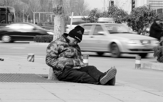 2月2日，鄭州市中州大道農(nóng)業(yè)路立交橋下，50歲的王文德打算在臨近春節(jié)前再接些零活兒，由于疲憊，他睡著