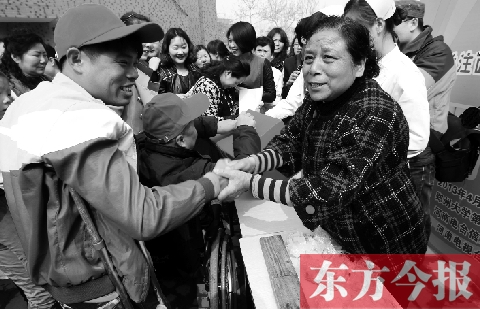 昨日，鄭大四附院的大樓前，“面人鄭”鄭玉芬（右）向前來(lái)捐款的殘疾人表示感謝