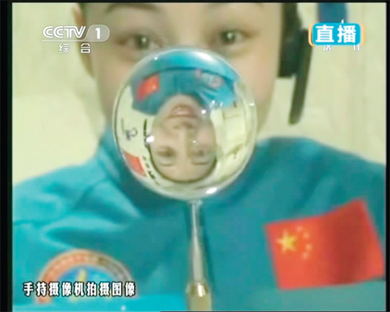 王亞平的倒影出現(xiàn)在水球中。新華社發(fā)（視頻截圖）