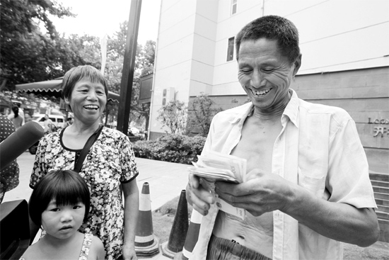 昨日，鄭州市明達路與豐慶路交叉口西300米路南，來自中牟的瓜農(nóng)拿到西瓜款，笑開顏東方今報記者袁曉強