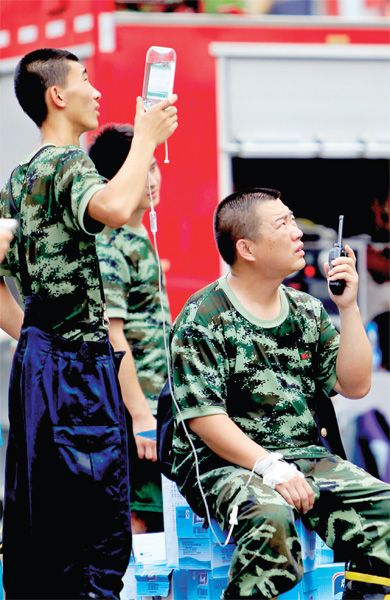 火場(chǎng)外，被消防戰(zhàn)士稱(chēng)為“李大隊(duì)”的救援人員掛著吊瓶現(xiàn)場(chǎng)指揮