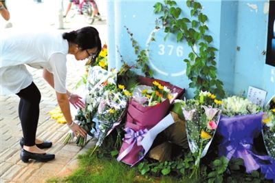 6月8日下午，記者來到廈門公交車爆炸事發(fā)現(xiàn)場橋下，附近已聚集了十幾個自發(fā)前來悼念的市民。橋墩下排放了一圈或黃或白的菊花，還有玖瑰、百合等。