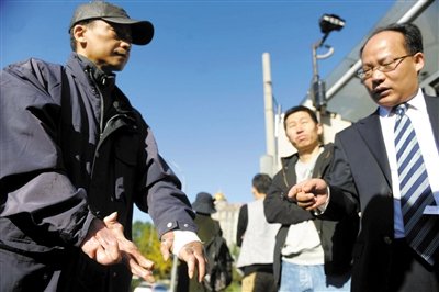 常林鋒在法院外展示雙手，他稱被燙傷的手因刑訊逼供且未得到及時(shí)救治