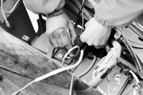 修車師傅正給電池做檢測 記者 張郁/攝 修車師傅正給電池做檢測 記者 張郁/攝