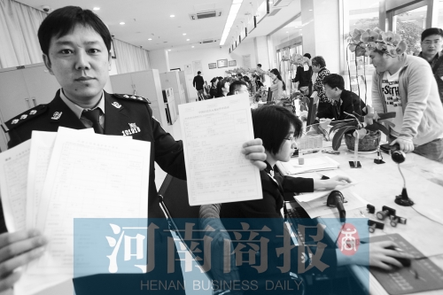 　民警左手拿的是新申請表，右手拿的是三份老申請表 王春勝/攝