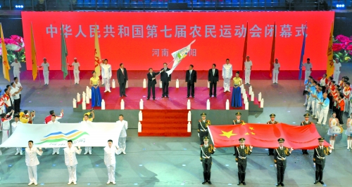 南陽市市長穆為民將農(nóng)運會會旗遞交到下一屆東道主吉林省松原市市長李相國手里。