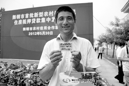 領(lǐng)到貸款，農(nóng)民開心地笑了。