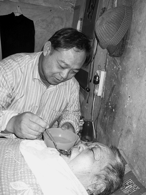 孝子李振亞在喂老母親喝水 孝子李振亞在喂老母親喝水