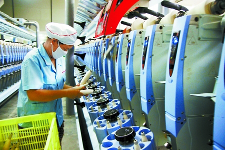 7月3日，在鄧州市永泰棉紡有限公司電腦控制全自動紡紗車間，紡織工人正在生產(chǎn)棉紗。