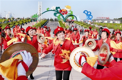 在中國(guó)國(guó)花園，伊川縣威武龍鼓藝術(shù)團(tuán)的精彩表演吸引眾多游客