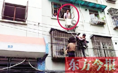 施救現(xiàn)場，劉鵬（圈內(nèi)）先用繩子捆住老太確保安全 勞動報(bào)記者 郭娜 供圖