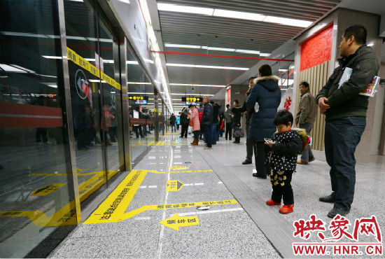 小朋友在等候區(qū)內(nèi)等待地鐵。