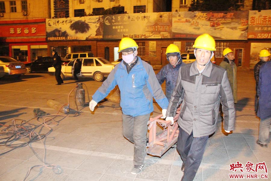 23點56分，第一塊兒廣告牌已經(jīng)分割完畢，地面上的20多名工人將拆除下來的鋼件撞車運走。