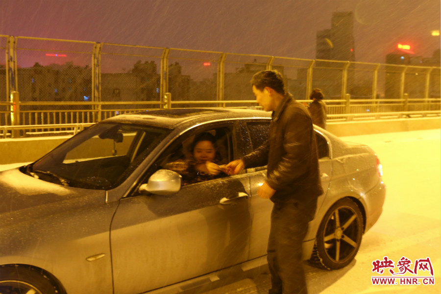 “推車人”幫助一輛車上坡后，收取“勞務(wù)費(fèi)”。