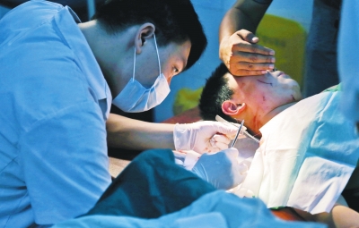 孩子身上有7道傷痕，其中兩道需要縫合，其他的均為擦傷，醫(yī)生正對他施治。