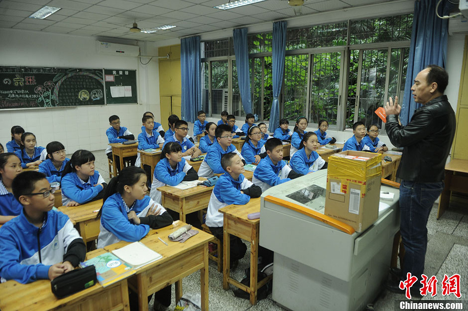 圖為老師正在向同學(xué)們講解用非智能手機(jī)對他們的好處。