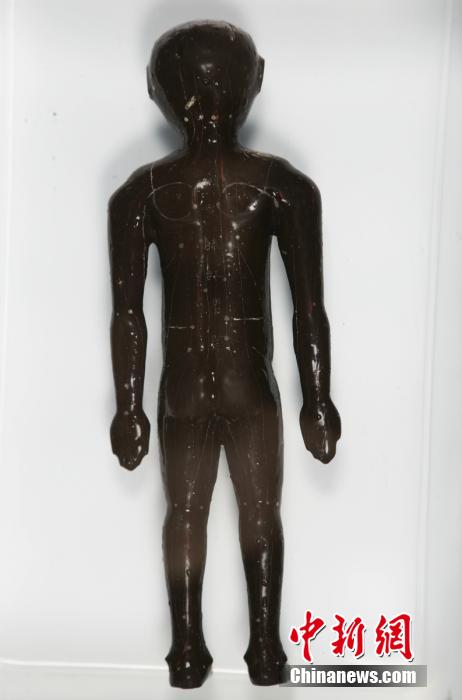 圖為出土的人體經(jīng)穴漆俑。