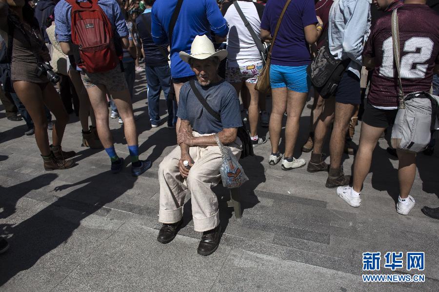 一名男子坐在參加不穿褲子搭地鐵的人群邊小憩。