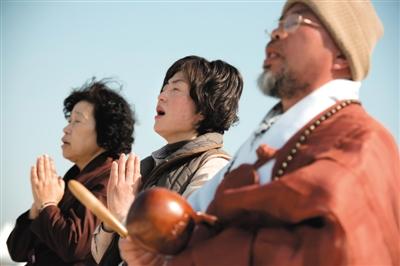 23日，一名僧侶引領(lǐng)人們?yōu)樗勒咂矶\。