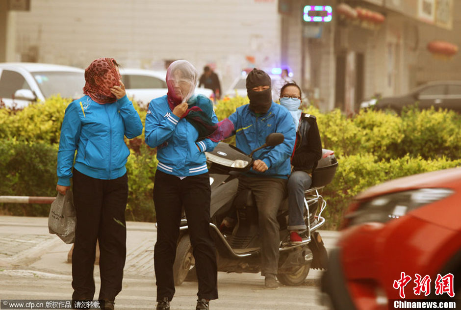 2014年04月23日，新疆維吾爾自治區(qū)吐魯番地區(qū)，市民戴著口罩行走在大風沙塵中的吐魯番市街頭。