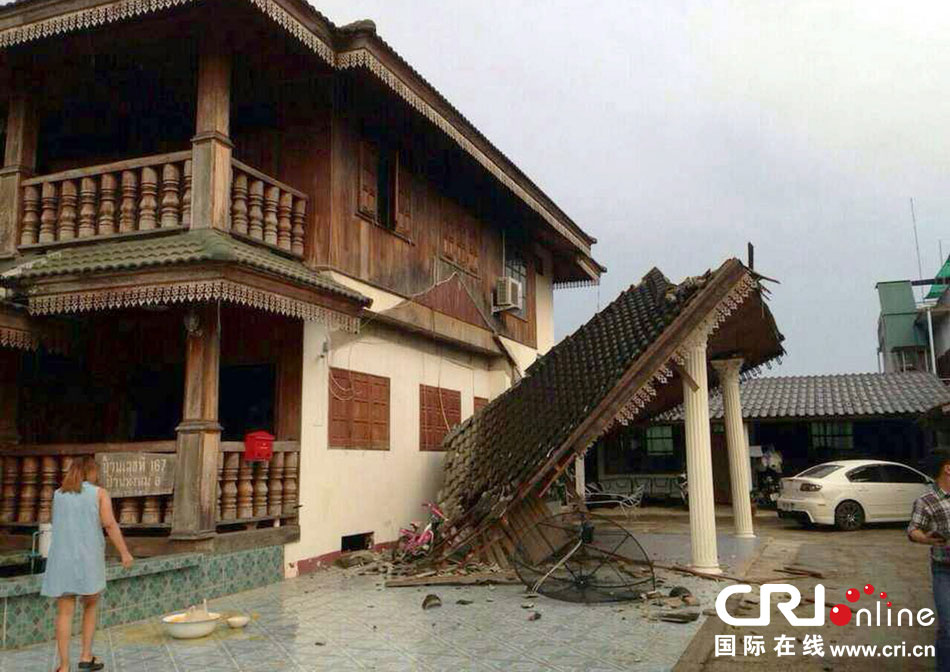 當(dāng)?shù)貢r間2014年5月5日，泰國清萊，一名婦女看著受損的房屋。 圖片來源：東方IC