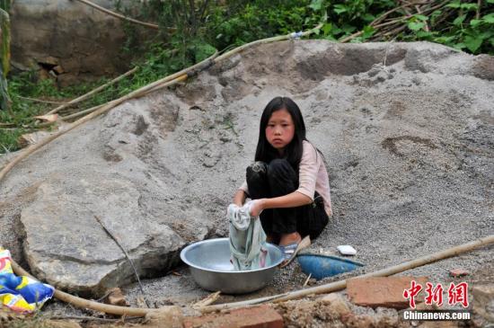 8月9日，云南巧家紅石巖村，10歲的劉鑫蕊在洗自己的衣服