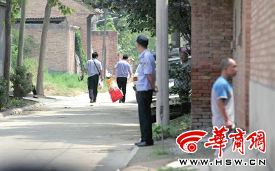 昨日,西安市閻良區(qū)譚家村,警方在事發(fā)的孫某家里勘查現(xiàn)場(chǎng)后,將提取的物證帶走 華商報(bào)記者 黃利健 攝