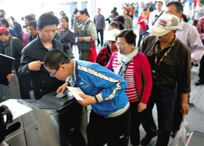 去年5月5日，14號(hào)線園博園站，乘客刷卡出地鐵。北京公交地鐵將實(shí)行計(jì)程票制，多乘坐多付費(fèi)。