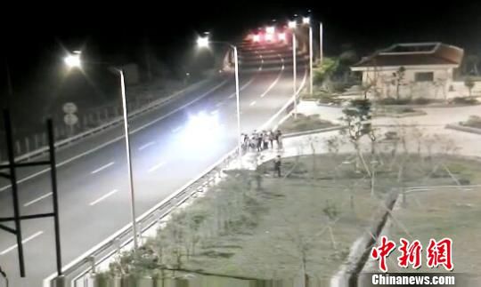 看到車輛經(jīng)過，孩子們便急忙跑到一旁的花圃上?！【焦﹫D　攝