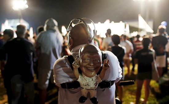 9月4日，新加坡，執(zhí)政黨的一場(chǎng)集會(huì)上，一名支持者背著一個(gè)李光耀的人偶。