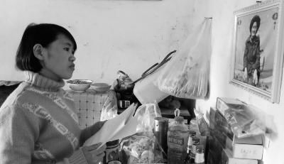 錢仁鳳站在母親遺像前。未能見母親最后一面是她的一大遺憾。