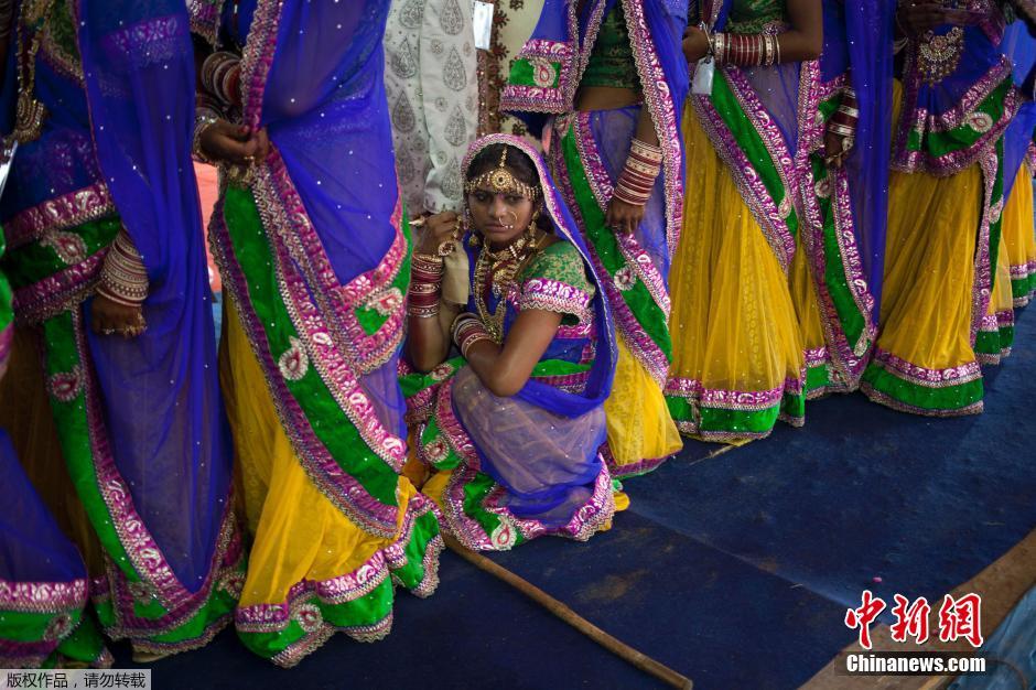 當(dāng)?shù)貢r(shí)間2014年6月15日,印度新德里,印度政府為數(shù)百對貧困新人舉辦集體婚禮。