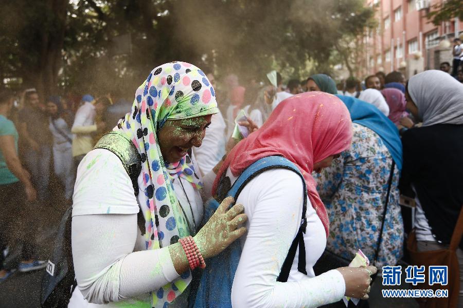 10月16日，在埃及首都開羅，兩名女青年在“彩色跑”活動(dòng)中躲避人們拋撒的彩色粉末。