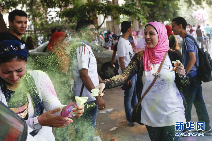 10月16日，在埃及首都開羅，一名女青年在“彩色跑”活動(dòng)中拋撒彩色粉末。