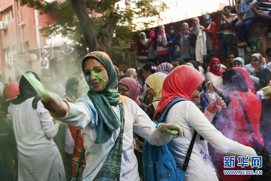 10月16日，在埃及首都開羅，一名女青年在“彩色跑”活動(dòng)中拋撒彩色粉末。